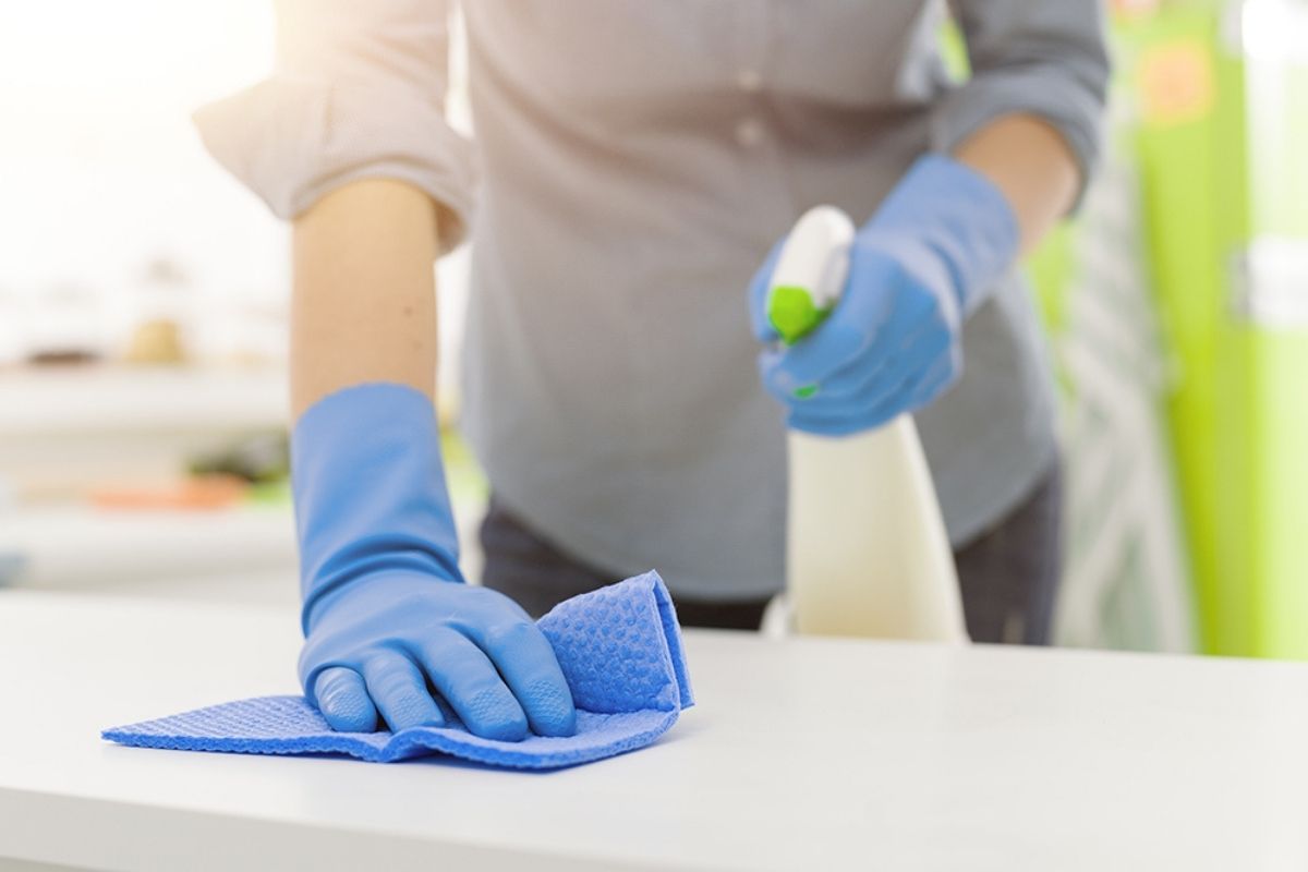 Woman cleaning with a spray detergent
