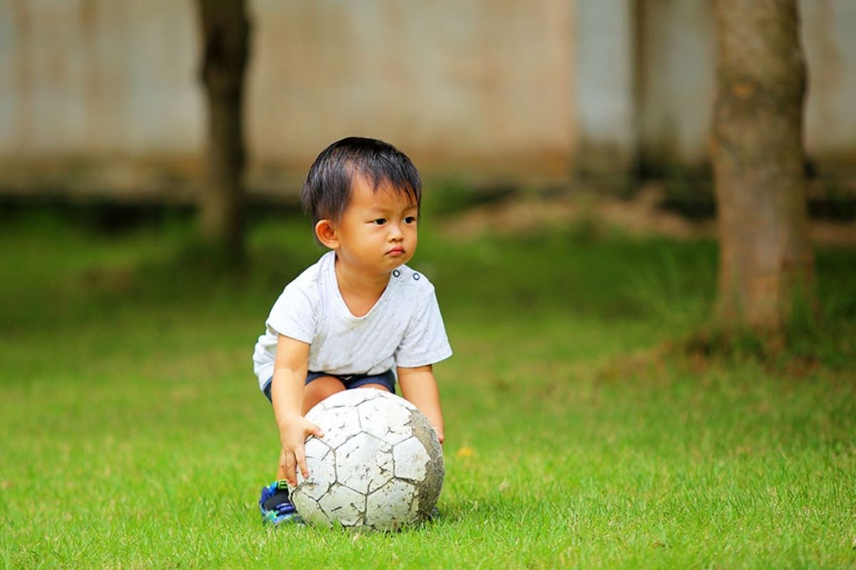 Asian boy playing football at a Preschool & Daycare Serving North Hollywood, Santa Monica & Van Nuys, CA